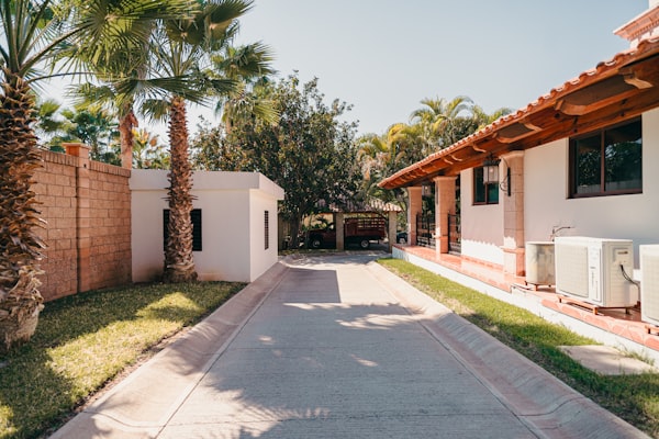 Residential home with driveway and palm trees in the service area
