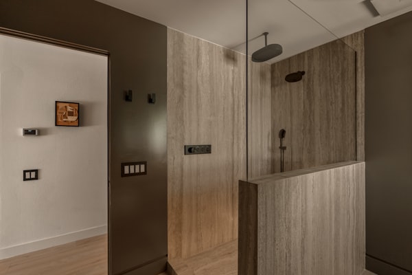 Modern bathroom with glass shower enclosure representing commercial plumbing fixtures